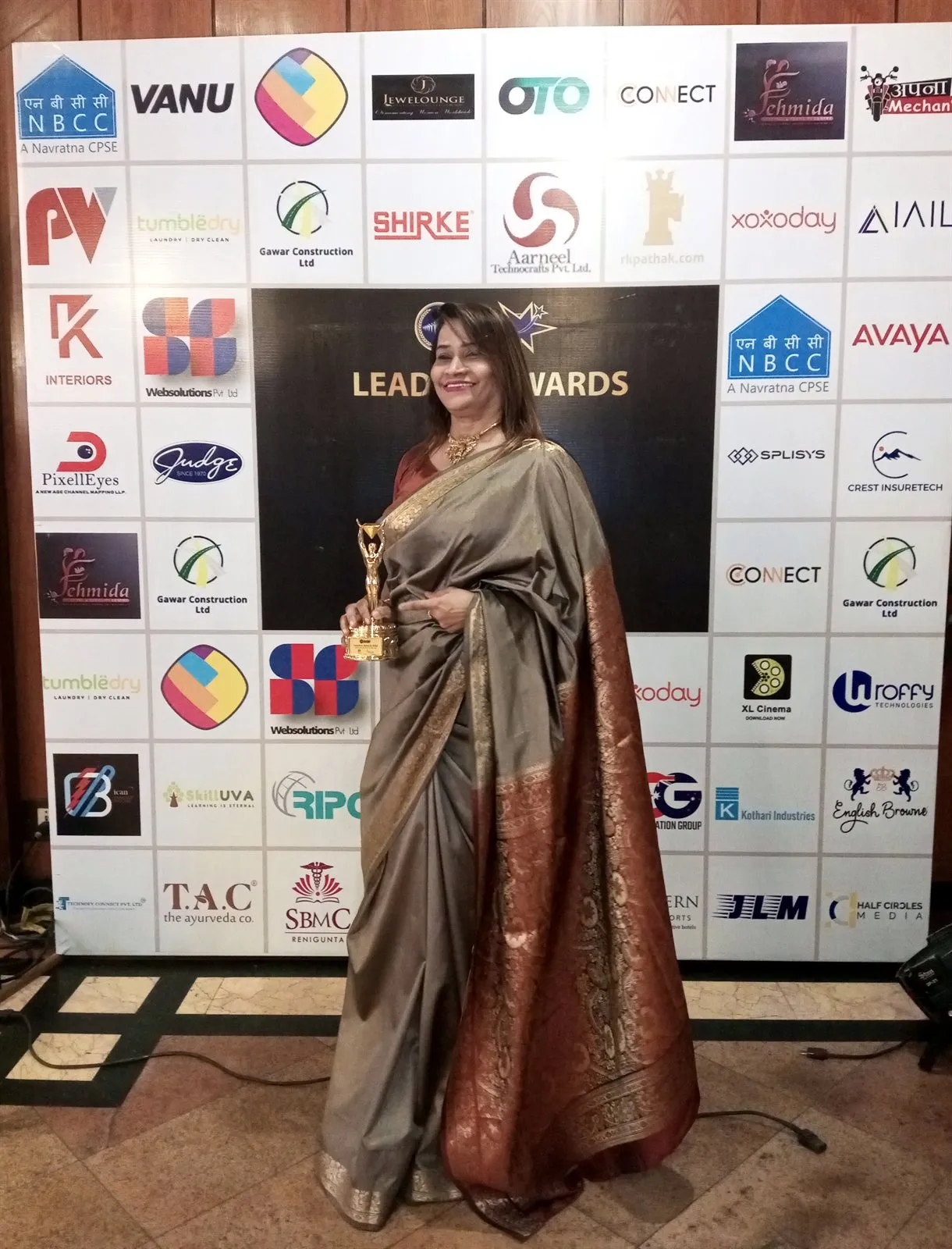 Dr. Fehmida Shaikh holding her award on the red carpet