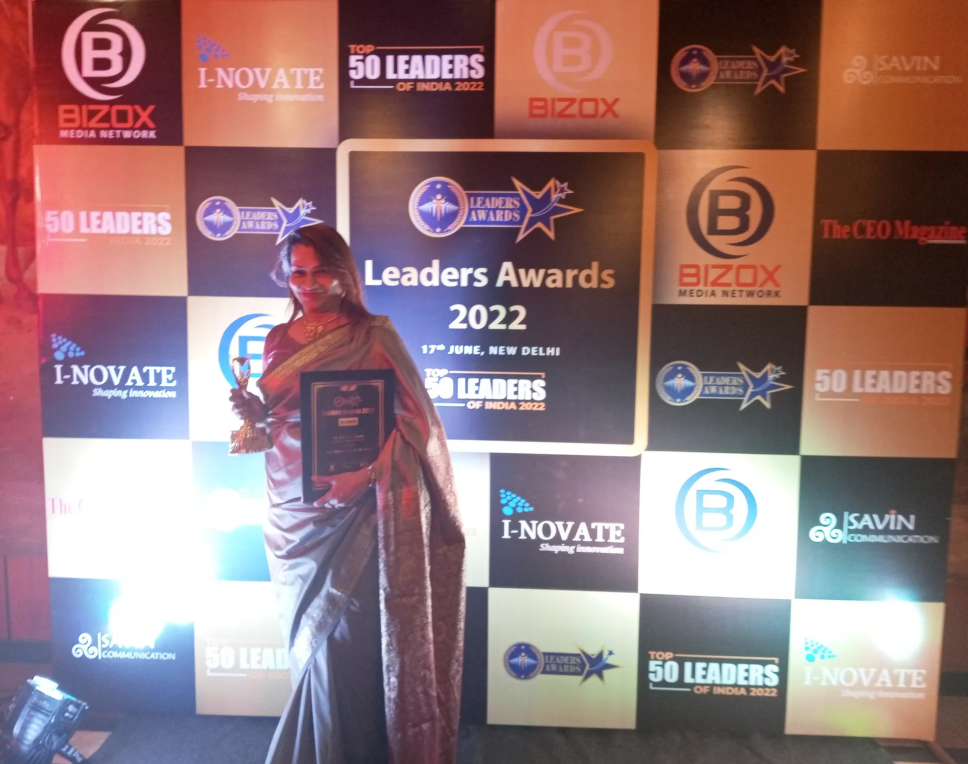 Dr. Fehmida Shaikh beside India's Top 50 Healthcare Leaders photo wall