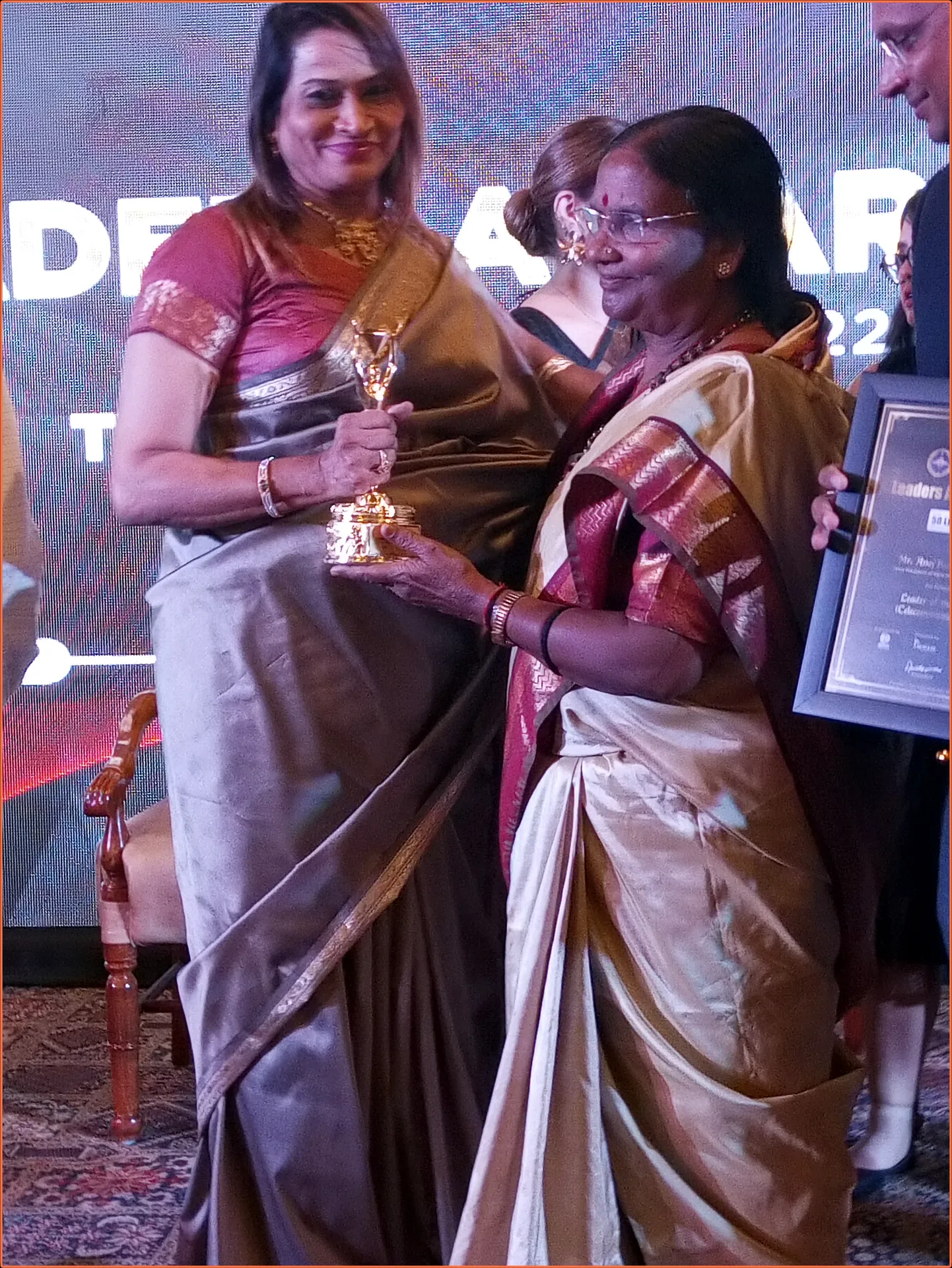 Dr. Fehmida Shaikh receiving the Best Gynaecologist of the Year trophy on stage from chief guest