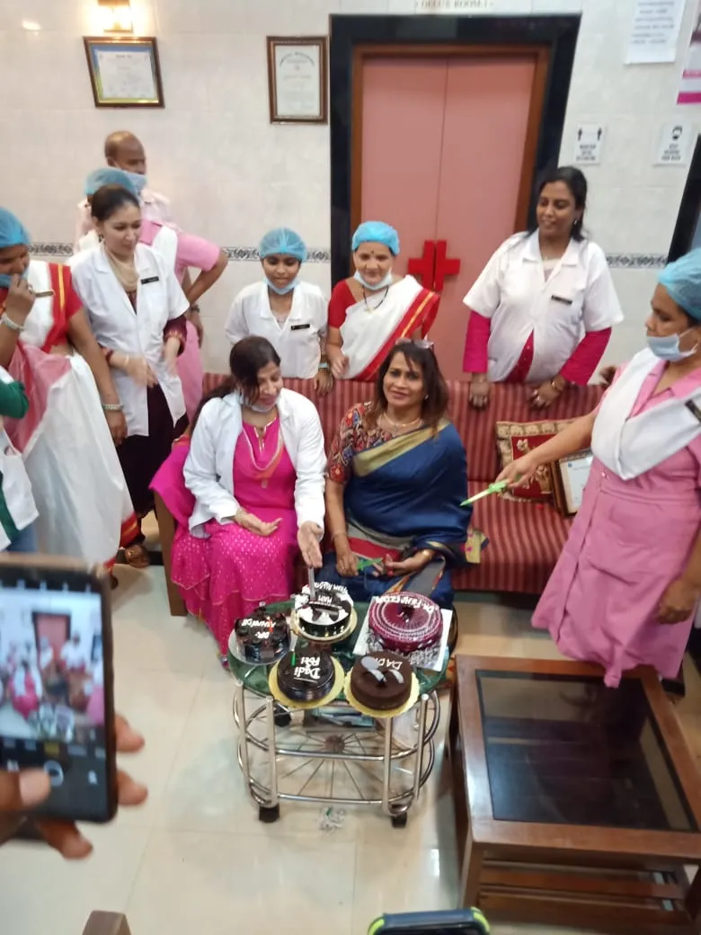 Hospital staff gathering for celebratory cake cutting