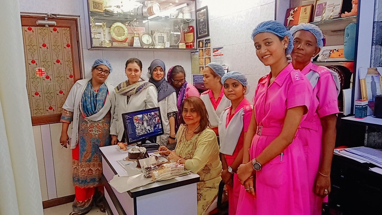 Dr. Fehmida Shaikh at clinic consultation desk with nursing care staff